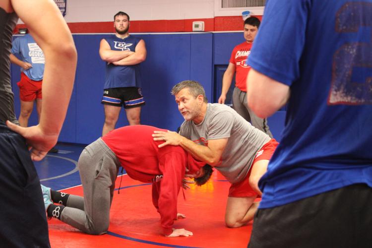 Coach Tim Stoudenmire (right) demonstrates a move with Tanner Mask to the rest of the Oglethorpe County wrestling team in a previous season. The Patriots are preparing for the Region Dual tournament on Jan. 13. (De Turner/The Oglethorpe Echo)