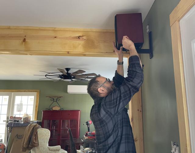 Willie Torres, co-owner of Town and Country Kafe, installs a speaker at the cafe and restaurant on Jan. 26, 2024. Torres has assisted with renovations to help the establishment open as soon as possible. (Margaux Binder/The Oglethorpe Echo)