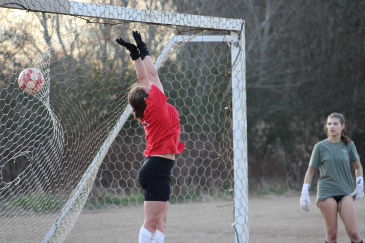 Senior goalie Anna Adams leaps to make a save during practice on Thursday, Feb. 1. Adams is returning from a season ending injury the season prior. (Photo/Owen Warden)