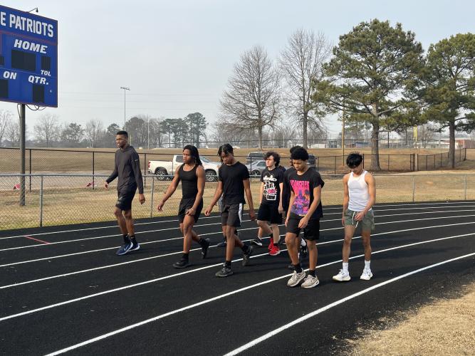 Boys track coach Maurice Freeman walks along the track with his athletes during practice. (Hank Tatum)