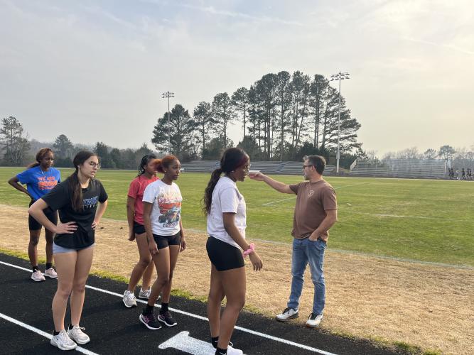 Girls track coach Tim Stoudenmire coaches his team at practice ahead of the team's first meet. (Photo/Hank Tatum)