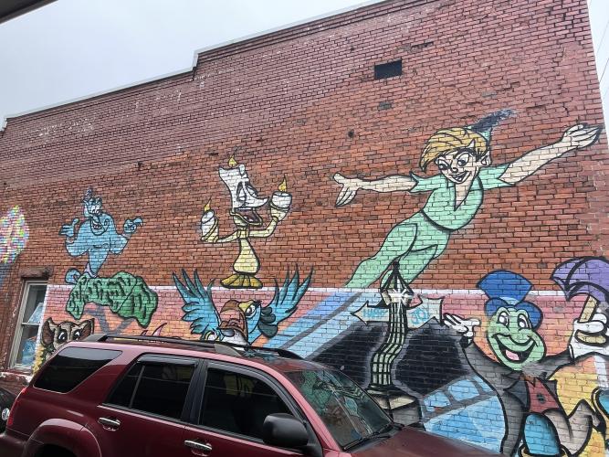 A & B Emporium, which is adjacent to Crawford Pizza in downtown Crawford, features a mural of Dis- ney characters. Alice Williamson, owner of A & B Emporium, said her mural has helped attract visitors  and spur business since it was painted about five years ago. (Margaux Binder/The Oglethorpe Echo)