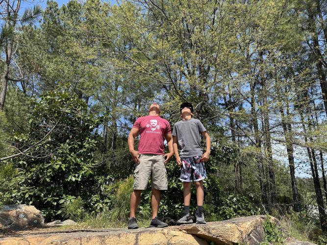 Anthony Tambling (left) and his son Graysen Tambling attended the viewing event at the Oglethorpe County Library. The two stood on a nearby boulder to get a clear view of the sun. (Photo/Izzy Wagner)