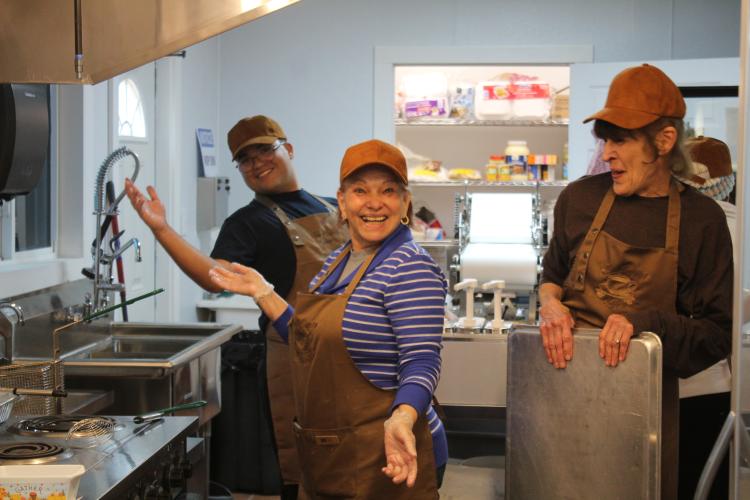 Justin Loggins (from left), Amy Delfin-Torres and Sandy Pavlosky prepare food for customers in the kitchen at Town and Country Kafe. Delfin-Torres, one of the owners of the restaurant, works as the primary chef, creating and serving traditional Spanish dishes. (Sarah Myers/The Oglethorpe Echo)
