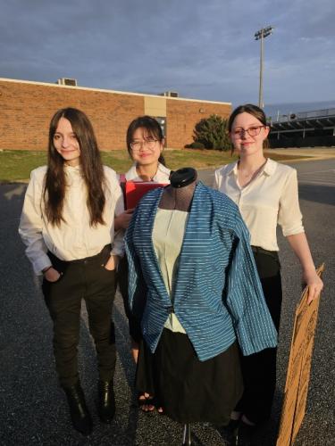 OCHS students Grace Foland, Ellen Hgay and Miley Christian (left to right) pose next to a design from their project "Fashion Forward." (Submitted Photo)