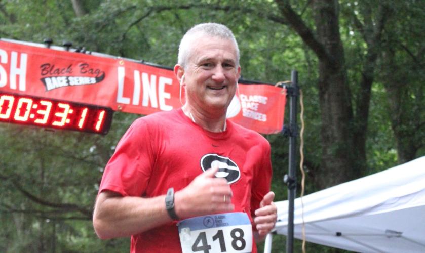 Lexington’s Jeff Paul crosses the finish line to place second in his age division (Male 55-59). He thanked his friend Randy Williams for the help. “He pulled me through that last half mile,” Paul said. (Sarah Coyne/The Oglethorpe Echo)