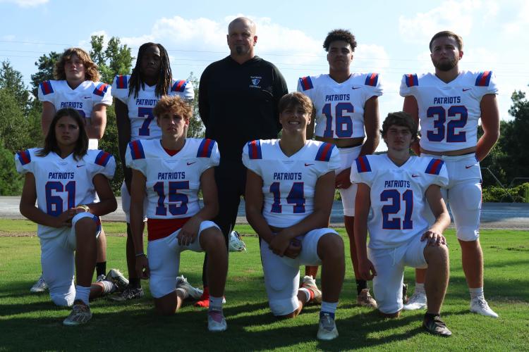 Mike Campbell stands with the OCHS linebacker group, as they poses for football picture day at the OCHS football field on Monday, July 31, 2023. Campbell is joined by his son Nash Campbell (far upper left), who is also coached by his dad on the baseball team (Landen Todd/The Oglethorpe Echo)