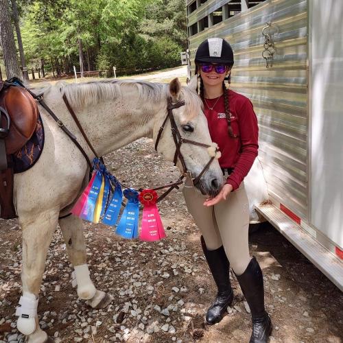 Raven Cooper stands with Lightning Bolt after she won several awards at Big Cheese Eventing in Walnut Grove. Cooper has owned Lightning Bolt for twelve years, "he will always be my best boy." Cooper is now a coach for the 4-H program, preparing county youth for the horse quiz bowl. (Submitted Photo)