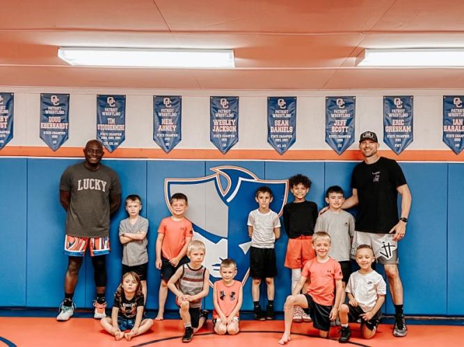 Varsity wrestling coach Steve Mason (right) and youth coach Nate Owens (left) held a three-day wrestling camp for kids this summer. Mason said he didn't teach the kids much at the start of camp, but they had fun just messing around in wrestling positions. (Submitted Photo)