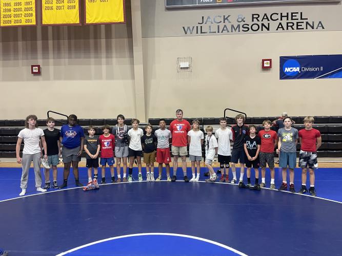 OCMS wrestling coach Craig Roberts (center) took 17 middle schoolers and rising freshmen to a camp at Emmanuel University last week. (Submitted Photo)