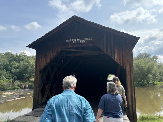 Naturalist Sarah Ratcliffe guides park visitors under Watson Mill Bridge, one of 16 remaining covered bridges in Georgia. (Jack Keys/The Oglethorpe Echo)