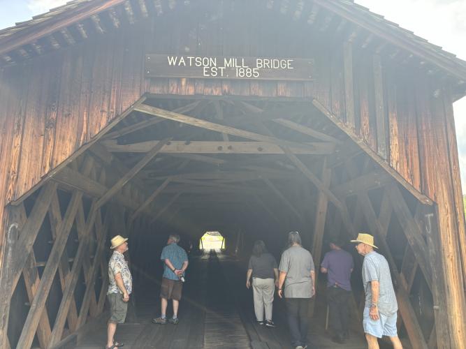 Naturalist Sarah Ratcliffe guides park visitors under Watson Mill Bridge, one of 16 remaining covered bridges in Georgia. (Jack Keys/The Oglethorpe Echo)