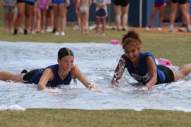 OCHS sophomores Khloe Eidson (left) and Zharia Burgess (right) take a turn on the slip-n-slide at the end of the camp. They are two of the current softball players who helped out at the softball camp. (Torin Smith/The Oglethorpe Echo)