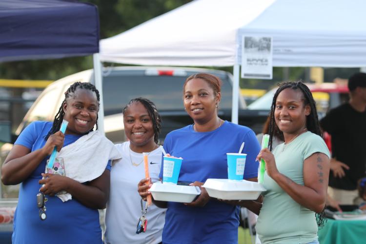 From left to right: Leslie Hardison, Sherry Witzher, Shawnteri Fleming and Tamika Barnett enjoy some popsicles and snow cones to help keep cool during the celebration. (Torin Smith/The Oglethorpe Echo)