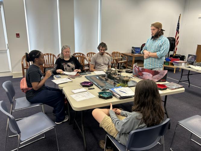 Trey Miller (right) speaks to four players in his Dungeons &amp; Dragons game held at the Oglethorpe County Library. The library will hold its final D&amp;D session of the summer at 11 a.m. on July 20. Also pictured, from left: Jayla Andrews, Pam Mitchell and John Lombardi. (Zeke Palermo/The Oglethorpe Echo)