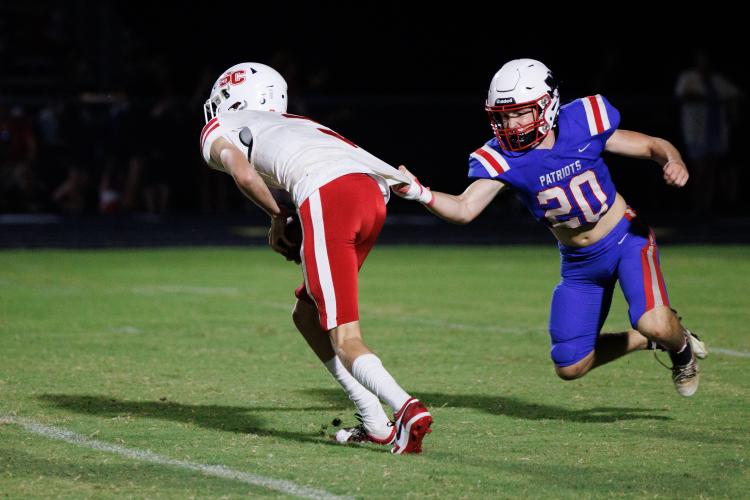 Oglethorpe County’s Keagan Moates grabs the jersey of Social Circle quarterback Luke Cross and tosses him to the ground for a sack on Aug. 16. Moates also had five tackles in the 48-41 loss to the Redskins. (Mark Johnson/The Oglethorpe Echo)