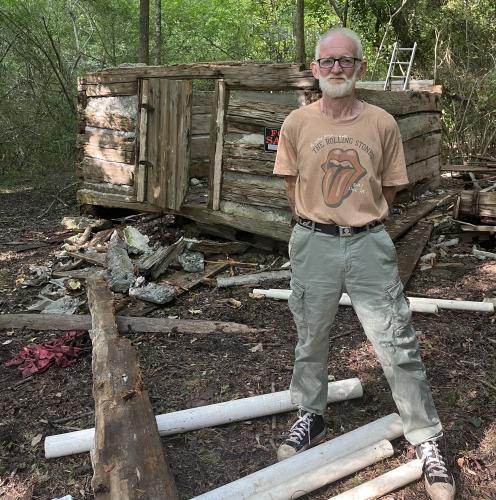 James Bennett stands in front of the historic structure his team found on the site of another project. His team is destructing the structure in hopes that it will be displayed for the public someday. (MCCAIN BRACEWELL/THE OGLETHORPE ECHO)