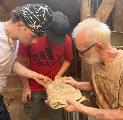 Left: Lucas Stephens, Caden Berggren and James Bennett look at an old newspaper found in an abandoned house they were commissoned to deconstruct. (MCCAIN BRACEWELL/THE OGLETHORPE ECHO)