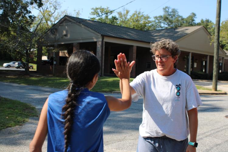 Head coach Jessica Ward provides encouragement for Oglethorpe County junior Evelyn Arvizu at cross country practice on Thursday, Aug. 22, 2024. Despite this being her first season coaching cross country, Ward “was just the biggest cheerleader” at the team’s opening meet, the Gorge to Beach XC Gathering 3K. (Audrey Pfitzner/The Oglethorpe Echo)