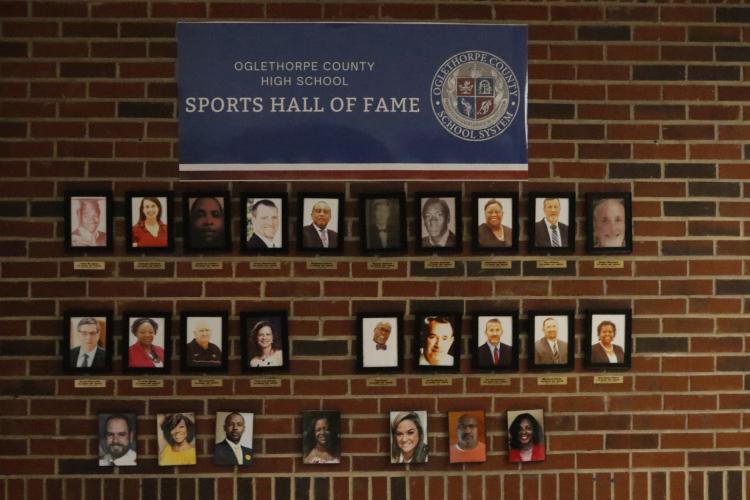 Photos of the members of the Oglethorpe County High School Sports Hall of Fame committee are displayed along a wall in the entry hall at OCHS. Eight more former athletes and coaches will be inducted this fall. (Torin Smith/The Oglethorpe Echo)