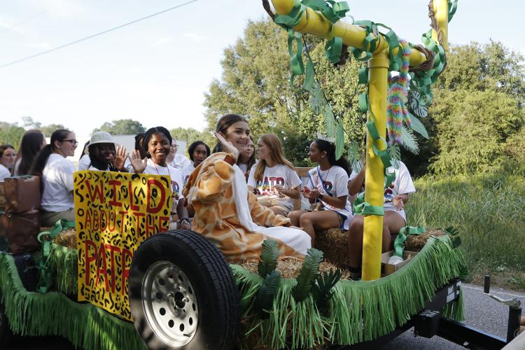 OCHS students wave to the crowd from their float during the  homecoming parade in downtown Crawford on Sept. 19, 2024. The  float had a jungle theme and the sign reads: “Wild about the  Patriots.” (Photo/McCain Bracewell)