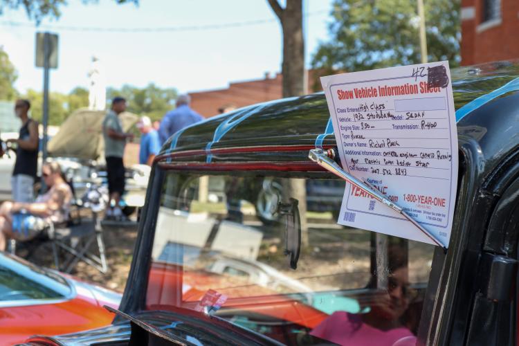 A show vehicle information sheet sits on the windshield of a 1932 Studebaker at the Firefly Cruise-In at the Oglethorpe County Courthouse on Sept. 22, 2024. The show vehicle information sheets provided detailed information to the event's judges and attendees. (Kendall Kelly/Oglethorpe Echo)