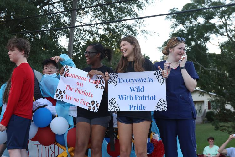 Students smile and hold up signs on the back of their float during the Oglethorpe County High School homecoming parade on Sept. 19, 2024 in downtown Crawford. (Photo/Avni Trivedi)