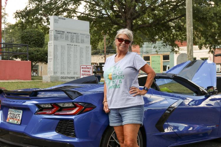 Carol Sanders poses with her 2023 Corvette Stingray R at the Firefly Cruise-In at the Oglethorpe County Courthouse, Sept. 22, 2024. Carol became more interested in cars when she married her husband, Howard, and they then joined the Streetmasters Car Club together. “We grew up with the best cars, the best music and the best clothes,” Carol said. (Kendall Kelly/Oglethorpe Echo)