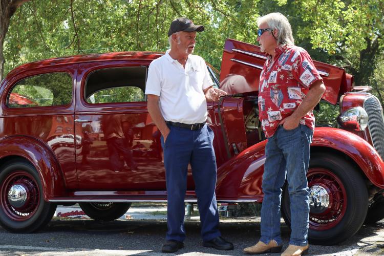 Mickey Archer (left) and Howard Sanders (right) talk in front of Archer’s 1936 Chevrolet at the Firefly Cruise-In at the Oglethorpe County Courthouse, Sept. 22, 2024. Archer, from Nicholson, started his car collection at 14 years old and has kept every car since. “I never cared about playing ball,” Archer said. “This has been my life ever since, wheels.” (Kendall Kelly/Oglethorpe Echo)