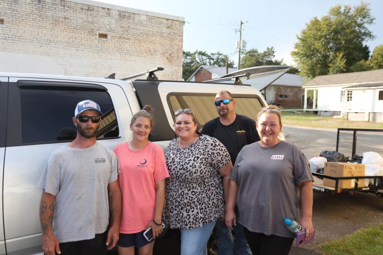 Samantha Paulk (left), Layne Paulk and Hazel Sanders, owner of Hazel’s Hair Salon in Lexington, help gather donations for the Cronic family. The donations filled the back of a truck and part of a trailer on Aug. 30. (TY JOHNSTON/THE OGLETHORPE ECHO)