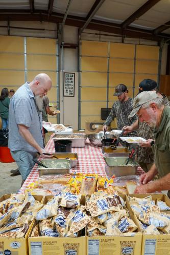 Carric Dooley, Josh Norman and Jerry Nation help themselves to a home cooked barbecue lunch. (Alex Perri/The Oglethorpe Echo)