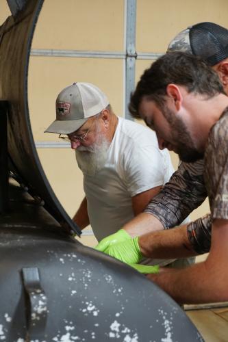 L-R Jerry and Tanner Nation help chop pork for lunch straight out of the smoker. (Alex Perri/The Oglethorpe Echo)