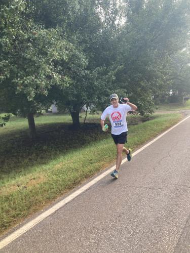 Glenn Tillman waves to the camera as he gets ready to cross the finish line at this year's Restoration Labor Day 5K in Crawford on Sept. 2. Tillman runs with his son Cory, who runs track and cross country at OCHS. (Submitted Photo)