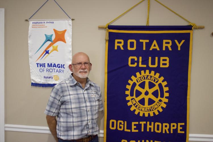 Rotary President Jeff Welch stands in front of the Oglethorpe County Rotary Club banner. Welch instituted a new raffle program intended to give local businesses new customers.