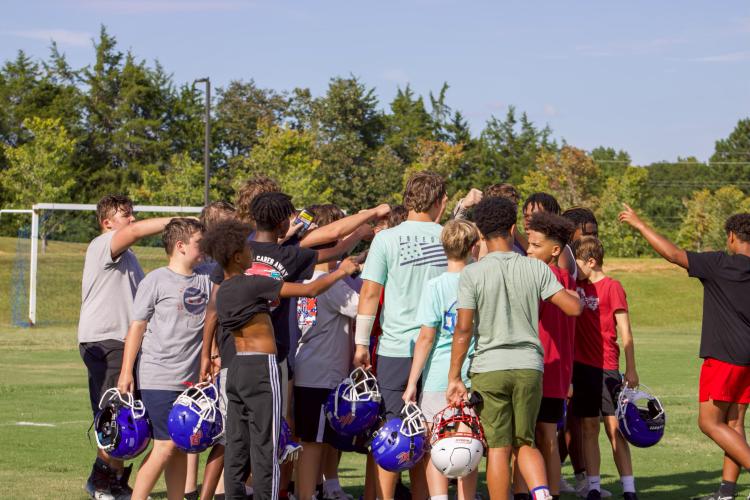 The OCMS football team ends practice with a team meeting and chant. The team won their game against Athens Academy 32-16 to improve their record to 5-0. (Audrey Pfitzner/The Oglethorpe Echo)