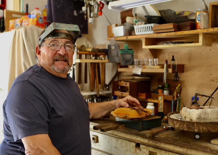 Bobby Teller works on a copper flower in his garage metalsmithing workshop in Crawford on Oct. 23. He works with a variety of metals, including copper, silver and iron in the workshop that he made by hand. (TY JOHNSTON/THE OGLETHORPE ECHO)