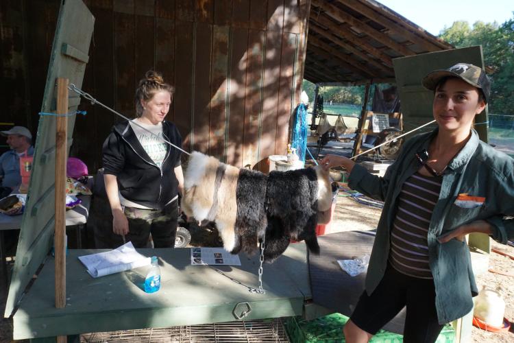 Hannah Ramirez (left) and Jessica Holm Boguski stand near a line of rabbit pelts from the Harvest Day's harvest. This year’s Harvest Day was held at Ramirez’s Renaissance Farmstead in Sandy Cross. (ALEX PERRI/THE OGLETHORPE ECHO)