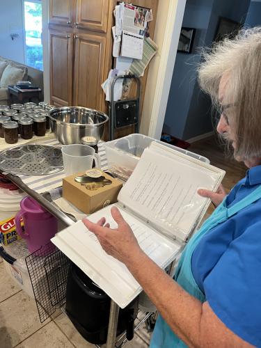 Kathy Howell flips through her menu of various jams, jellies and preserves. Her jellies come in 21 flavors, including peach bourbon and strawberry balsamic. (Kendall Kelly/Oglethorpe Echo)