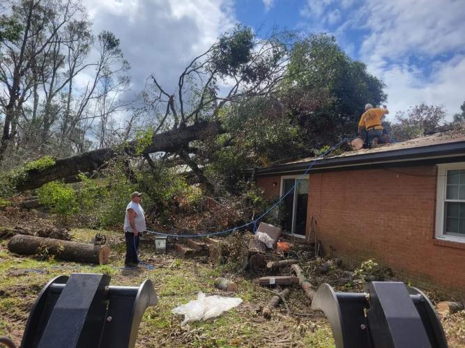 Members of the Georgia Baptist Disaster Relief team clear a tree off a roof in Vidalia, GA. Following the Sept. 24 landfall of Hurricane Helene, many yards are in disrepair and covered in debris. (Photo / Howard Sanders)