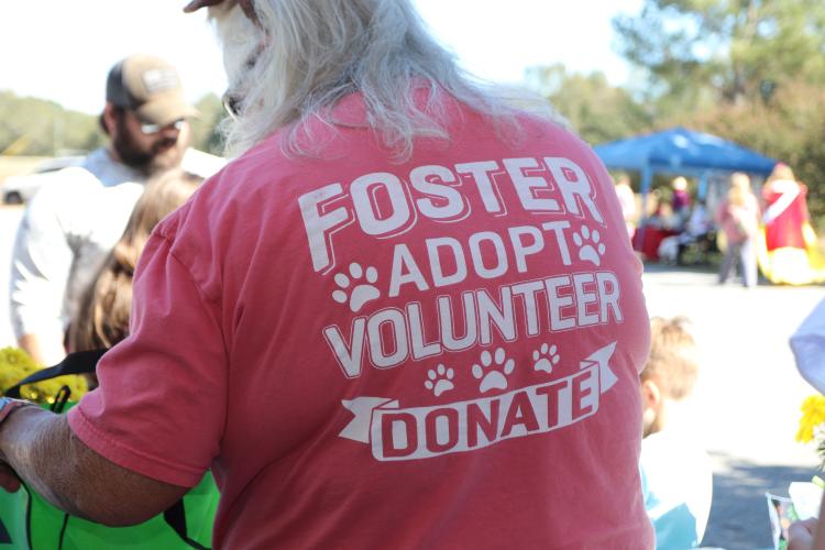 Volunteer Kelly Wall checks attendees in at the welcome table at Madison Oglethorpe Animal Shelter's Halloween Costume Party on Saturday, Oct. 19. Wall said she has been volunteering at the shelter for over two years and has fostered over 120 dogs. "There's so much need," Wall said. "We always need volunteers and fosters." (Ella Kroll/The Oglethorpe Echo)