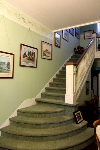 A carpeted staircase leads to the upstairs with four bedrooms and one full bathroom on Monday, Oct. 21 in Lexington, Georgia. Walter Faust's second wife installed a wall before the stairs when the area was one large room for entertaining. Roger NeeSmith had to add a step to the staircase when removing the wall to restore the room to its original layout. “I can't tell you how many junior and senior pictures have been made here,” Rosa NeeSmith said. (Emily Slepsky/The Oglethorpe Echo)