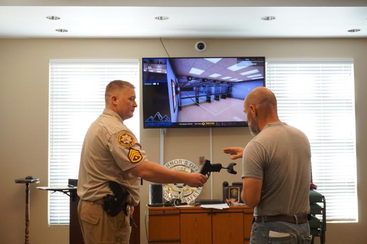 Sgt. Johnathan Duke shows Aaron Reynolds, pastor of Sonlight Baptist Church, how to use the virtual reality gun at the Oglethorpe County Sheriff's Office as part of the first church safety class. The Sheriff’s Office hopes to hold classes for other churches. (Alex Perri/The Oglethorpe Echo)
