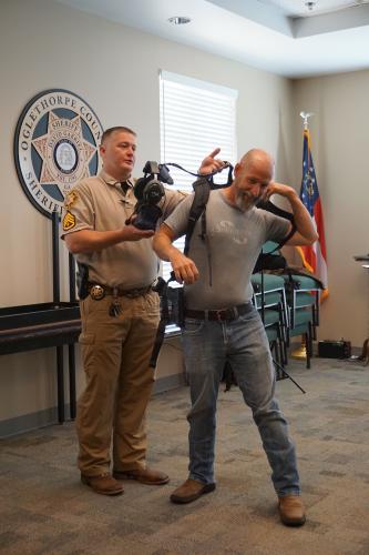 Sgt. Johnathan Duke assists Aaron Reynolds, pastor of Sonlight Baptist Church, with a virtual reality headset during the church safety class. The class also included time on the gun range. (Alex Perri/The Oglethorpe Echo)