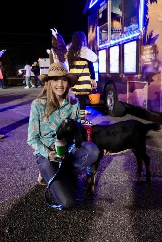 Kaylee Nold and her goat Sophia enjoy some refreshing Kona Ice amid the lights, candy and celebrations of Trunk or Treat at the Oglethorpe County rec center on Oct. 30. (Saylor Williams/The Oglethorpe Echo)