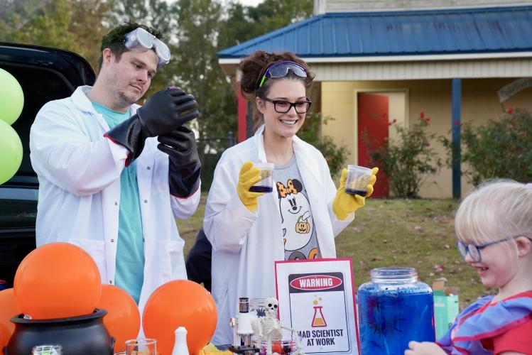 Mad scientists Dylan Fields and Kelli Fields create and mix spooky potions at this year’s eighth annual Trunk or Treat event at the Oglethorpe County rec center. Kids lined up to face their fears and reach into the gooey spider enclosure as fog machines filled the air and candy filled their baskets. (Saylor Williams/The Oglethorpe Echo)