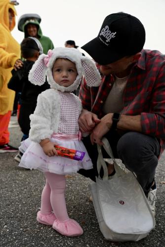 Brooklyn Roach, who is 1, clutches her first candy bar of the night as she begins her rounds through the eighth annual Trunk or Treat at the Oglethorpe County Rec Department with her dad smiling down at her. (Saylor Williams/The Oglethorpe Echo)