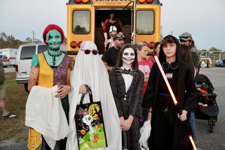 Rylee Stanley (from left), Rebecca Jones, Kinley Grimes and Julian George went all out for the rec department’s Trunk or Treat. The eighth-graders stand in front of one of the night’s biggest attractions: Ms. Frizzle’s Magic School Bus. (Saylor Williams/The Oglethorpe Echo)