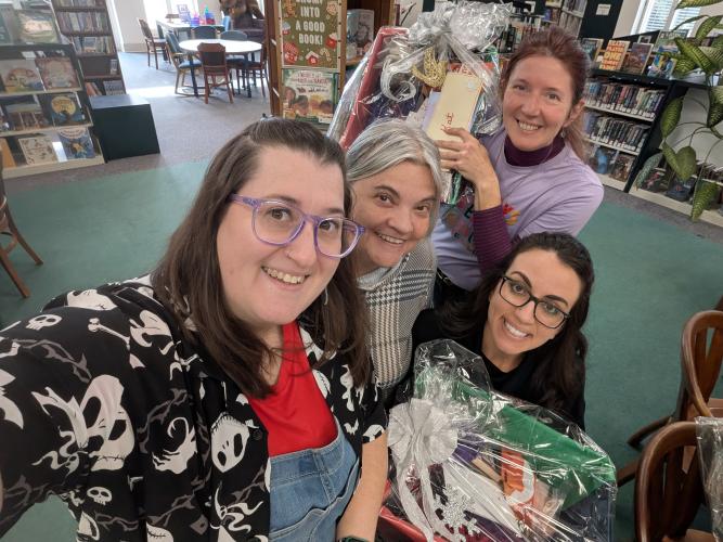 Nicole Hensley (from left), Laura Lindsey, Katherine Ratcliffe and Jessica Ellis hold gift baskets that were created by the Friends of the Oglethorpe County Library volunteers and presented as gifts to the library staff. Items in the baskets were donations from local businesses. (Submitted Photo)