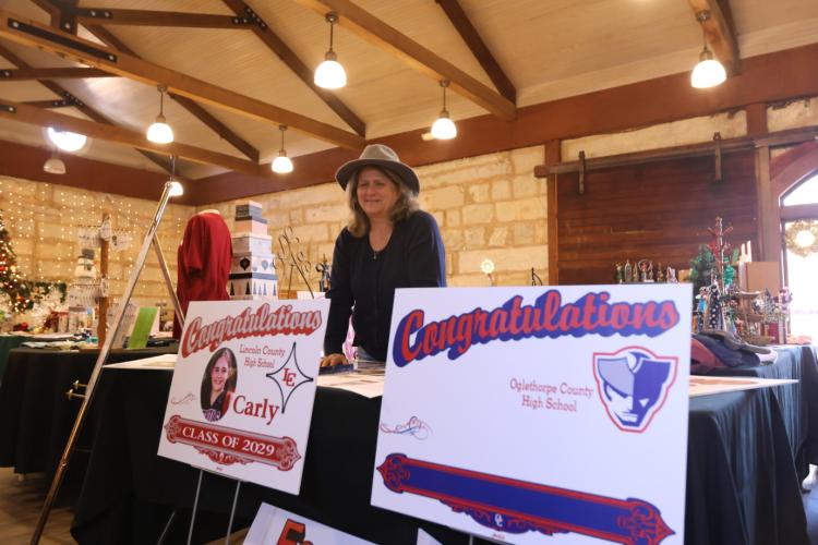 Lexington's Gina Holloway showcases samples of signs at the Christmas Marketplace on Sunday at the Historic Crawford Depot. Letter It!, Holloway's business in Lexington creates custom printed and vinyl signs. (Photo/ Sarah Coyne)