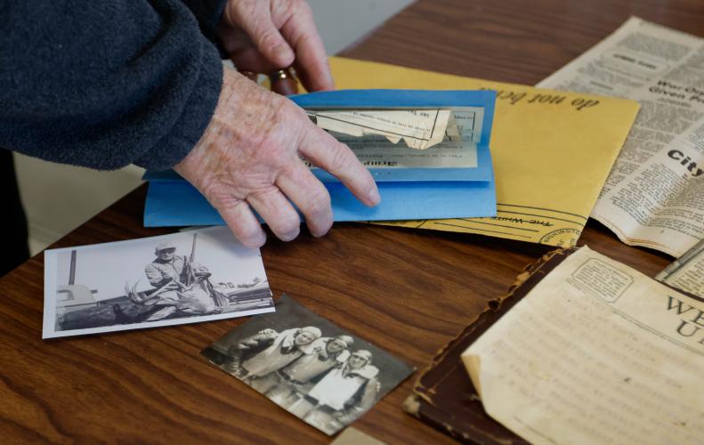 Brenda Coley folds a worn military document back into a sheet of protective paper while  within the Oglethorpe County Library in Lexington, Georgia on Monday, Jan 13, 2025. (Photo/Felix Scheyer)